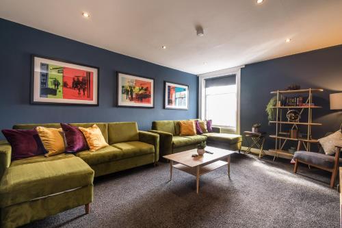 a living room with a green couch and a table at Host & Stay - The Georgian Quarters at Canning in Liverpool