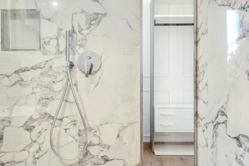 een badkamer met een douche en marmeren muren bij Nelli Rooms Via Veneto in La Spezia