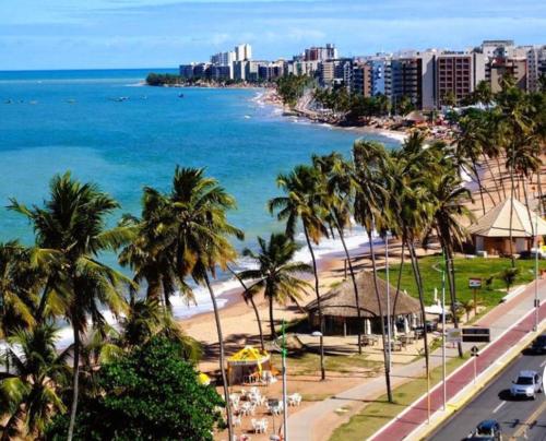 vistas a una playa con palmeras y al océano en Apt em condomínio de luxo à beira mar de Jatiúca, en Maceió