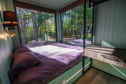 uma cama num quarto com uma grande janela em BRENDIS -'Virš Ąžuolų' - Forest SPA - FREE jacuzzi em Paplatelė