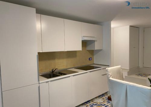 une cuisine avec des armoires blanches et un évier dans l'établissement Casa Fornillo, à Positano