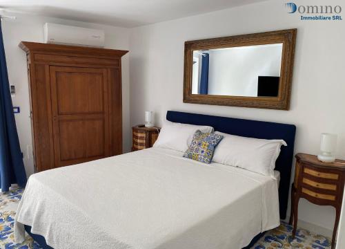 une chambre avec un lit avec un miroir au mur dans l'établissement Casa Fornillo, à Positano