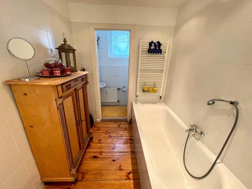 ein Badezimmer mit einer Badewanne, einem Waschbecken und einem Spiegel in der Unterkunft romantische Ferienwohnung Sachsenhof 4 in Klingberg