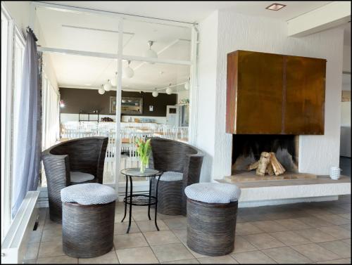 un restaurant avec une cheminée, des chaises et une table dans l'établissement Varbergs GK Östra Hotell, à Grimeton