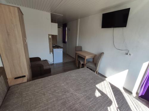 a bedroom with a bed and a television on the wall at OZone Apartman in Siófok