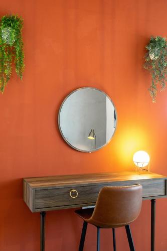a mirror on a orange wall with a chair at HOT TUB Sea View SPA in Hvar