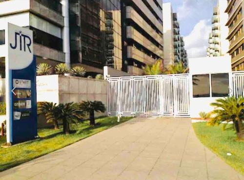 a white fence in front of a building at Apt em condomínio de luxo à beira mar de Jatiúca in Maceió