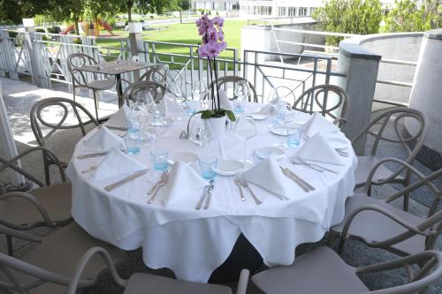 a white table with glasses and silverware on it at Boutique Hôtel de l'Ecu Vaudois in Begnins
