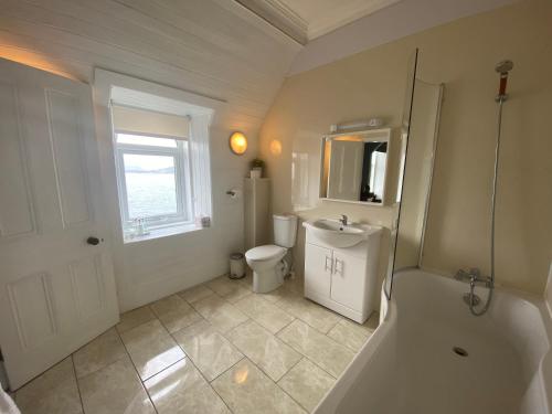 a bathroom with a tub and a toilet and a sink at Barriemore Oban in Oban