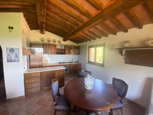 cocina con mesa de madera y sillas en Agriturismo Valborgina, en Castiglione della Pescaia
