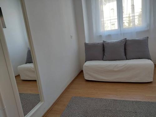 a living room with a couch in front of a mirror at B30 Apartman in Budapest