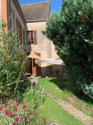 a view of a yard with a tent and a house at La Grenouille Noire in Marcillat-en-Combraille