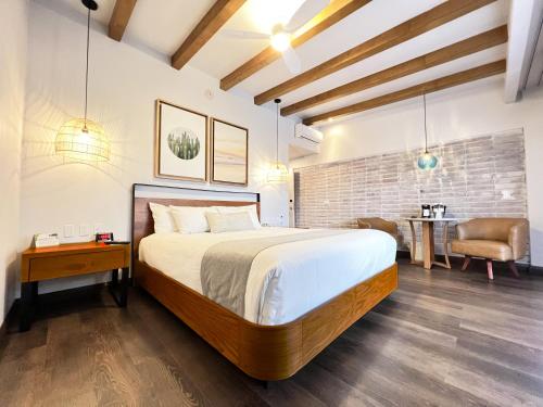a bedroom with a large bed and a living room at San Nicolas Hotel Casino in Ensenada