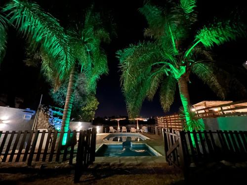 a resort with a pool and palm trees at night at Costadorada in Villa Carlos Paz