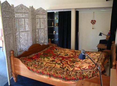 een slaapkamer met een groot bed en een gordijn bij perelaar in Langelille