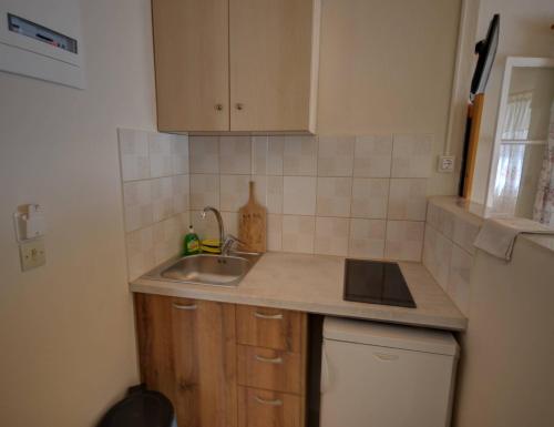 a small kitchen with a sink and a refrigerator at Mikeys Apartments in Paleokastritsa