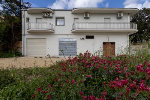 a white house with a balcony and flowers at LA CASA DI MAMMA 'NTO in Castrofilippo