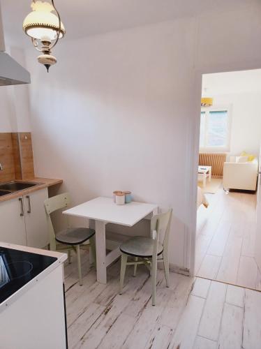 une cuisine avec une table et des chaises dans une pièce dans l'établissement Superbe Appartement en plein centre-ville de Crépy, à Crépy-en-Valois
