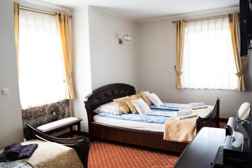 a bedroom with a bed and two windows at Apartament z widokiem na morze in Krynica Morska