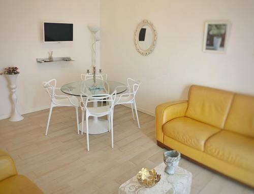 un soggiorno con tavolo e divano giallo di La Finestra Sul Mare a Castro di Lecce