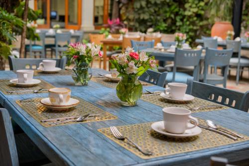 a blue table with plates and cups and flowers on it at Hotel Casa Vertiz in Oaxaca City