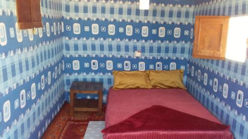 a bedroom with a bed with a blue and white wall at Club Camping des pêcheurs in Dakhla