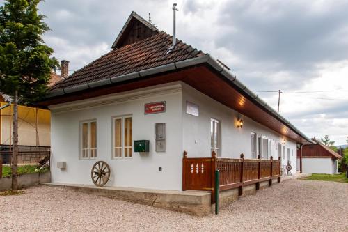 a small white building with a brown roof at Vidéki vendégház Szögliget in Szögliget