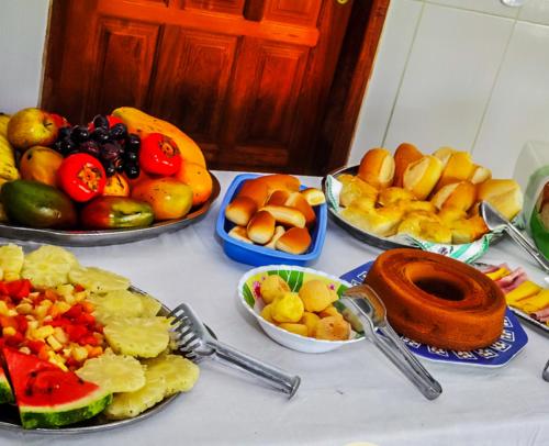 a table topped with plates of fruits and vegetables at VOA Pousada Dos Jasmins in Serra