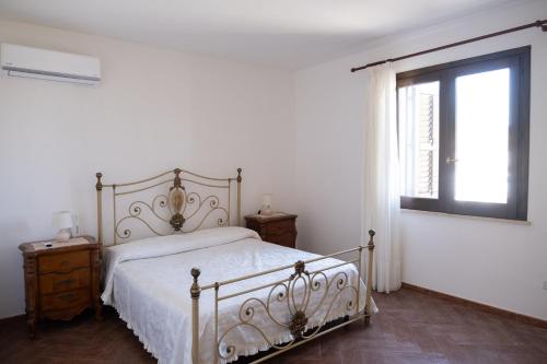una camera bianca con un letto e una finestra di Villa Lina a Mazara del Vallo
