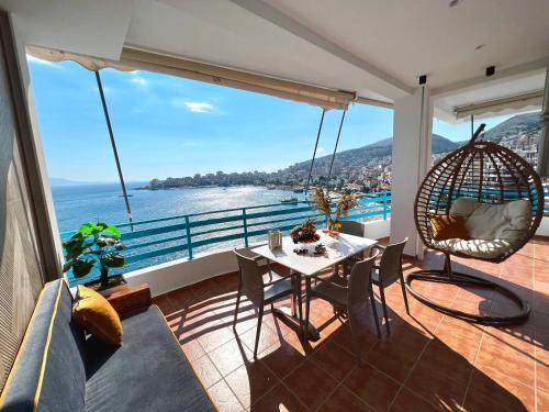 uma varanda com mesa e cadeiras e vista para o oceano em Aquamarine Apartments em Saranda