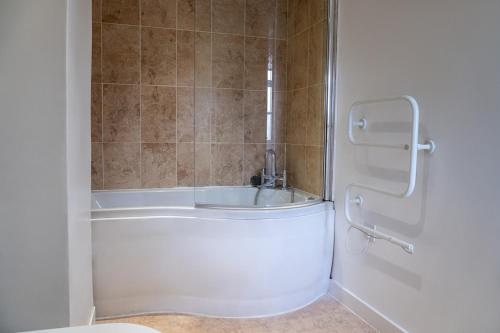 a bathroom with a bath tub and a toilet at cosy and peaceful near Ashford town centre in Kent