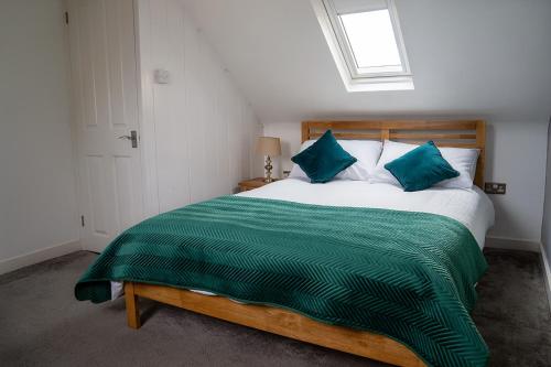 a bedroom with a large bed with a green blanket at cosy and peaceful near Ashford town centre in Kent
