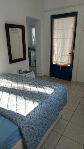a bedroom with a bed and a mirror and a window at Ακροδεα in Áno Gávrion