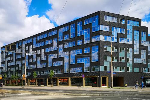 a large building with blue windows on a street at Lumen Studio in Wrocław