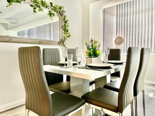 uma sala de jantar com uma mesa branca e cadeiras verdes em Winter Gardens Owners Suite Blackpool em Blackpool