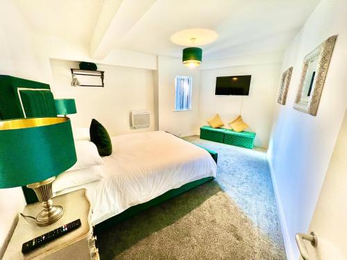 um quarto com uma cama e uma mesa com um candeeiro em Winter Gardens Owners Suite Blackpool em Blackpool