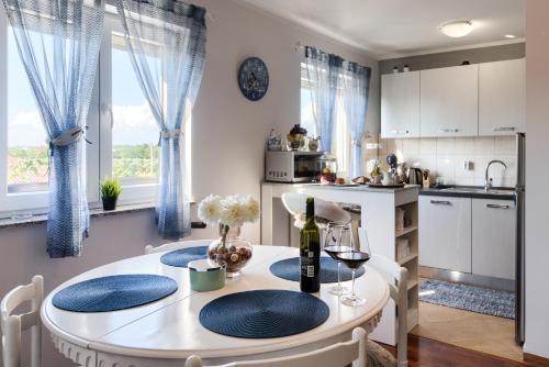 a kitchen and dining room with a table and chairs at Apartmani Plavi val in Vodnjan