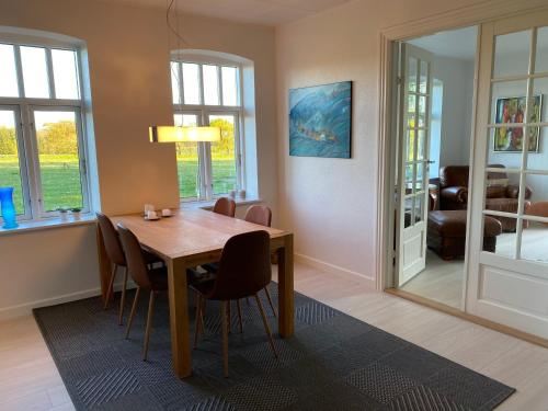 a dining room with a wooden table and chairs at Hyggelig aftægtsbolig i hjertet af Sønderjylland in Branderup