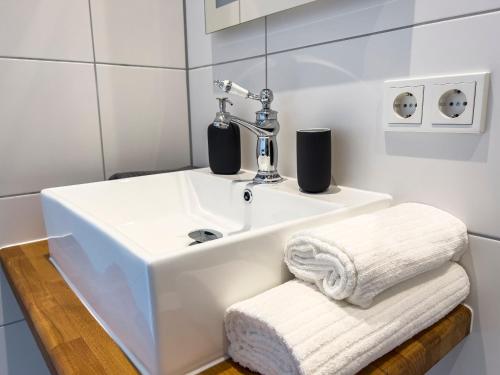 baño con lavabo blanco y toalla en Konrads Pension, en Solms-Oberbiel