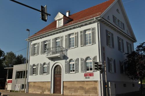 an old white building with a red roof at Achtender in Metzingen