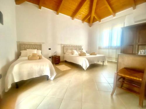 een grote kamer met 2 bedden en een raam bij Villa Pedrosu in Casa Linari
