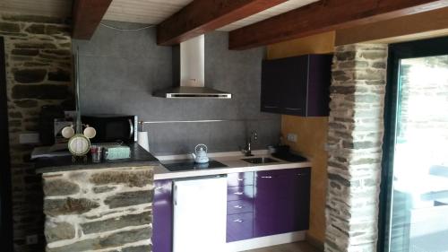 a kitchen with a sink and a stone wall at Albergue Oasis in Sarria