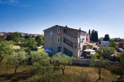 a house in the middle of a field with trees at Apartmani Plavi val in Vodnjan