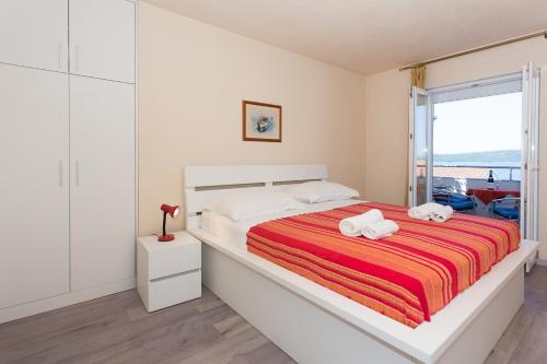 a white bedroom with a bed with towels on it at Apartments Alajbeg in Trogir
