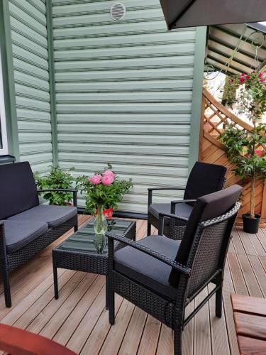 a patio with chairs and a table with a vase of flowers at Vintage Four in Haapsalu