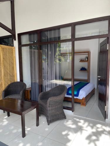 スンギギにあるBeach Club Lombok by Bale Solahのベッドとテーブルと椅子のある寝室