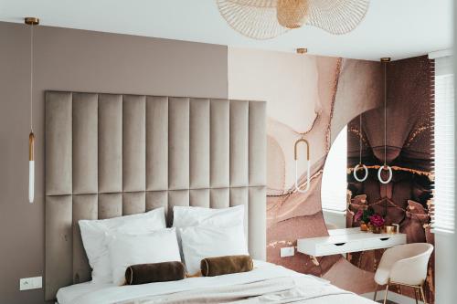 a bedroom with a bed and a wall with a painting at Studio Mrągowo in Mrągowo