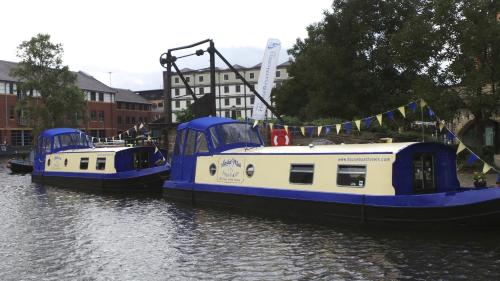 two blue and white boats in a river at Houseboat Hotels in Sheffield