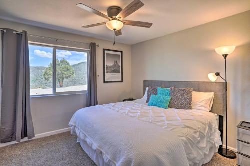 Schlafzimmer mit einem Bett, einem Deckenventilator und einem Fenster in der Unterkunft Prescott Sunset Sanctuary with Panoramic View in Prescott