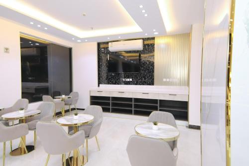 a restaurant with tables and chairs and a large window at شقق كلاس للشقق المخدومة اقتصادي in Hail